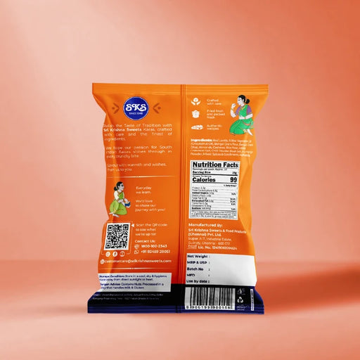 The back of an orange 8X5 brand potato chip bag standing upright on a dark blue display block against a peach-pink gradient background.